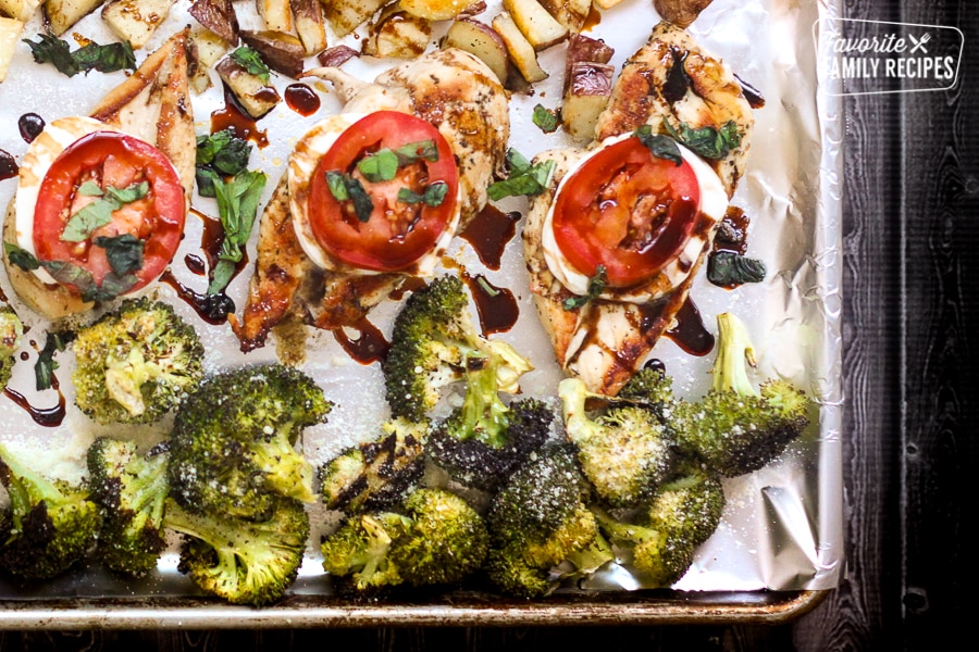 A sheet pan filled with chicken, potatoes, and broccoli.