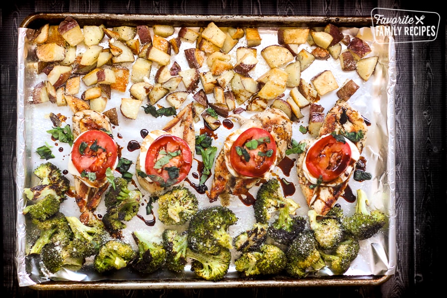 Caprese chicken, herbed potatoes, and broccoli roasted on a sheet pan.