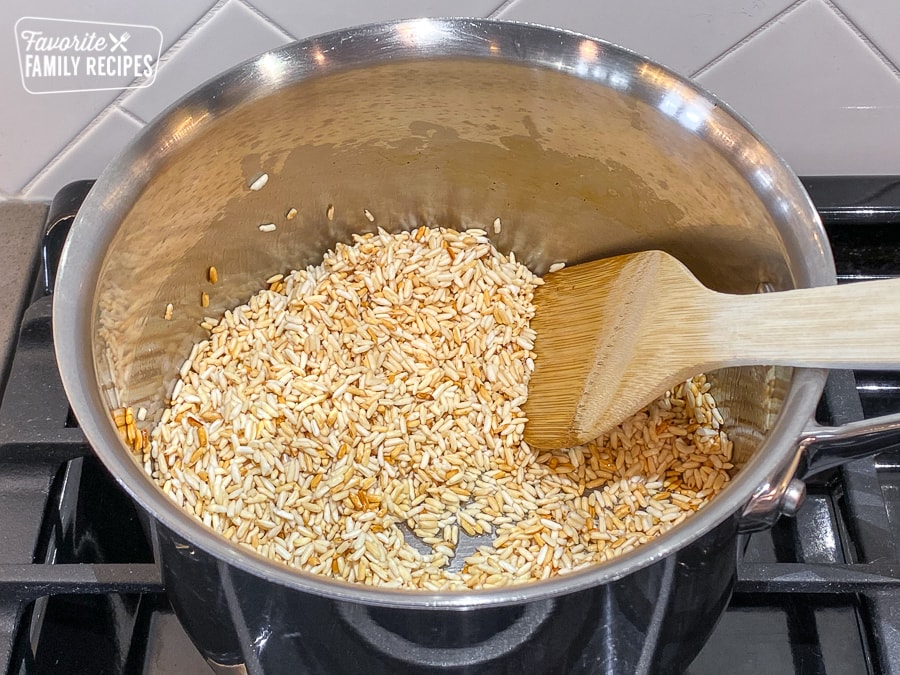 White rice being browned in a pot to make Mexican rice
