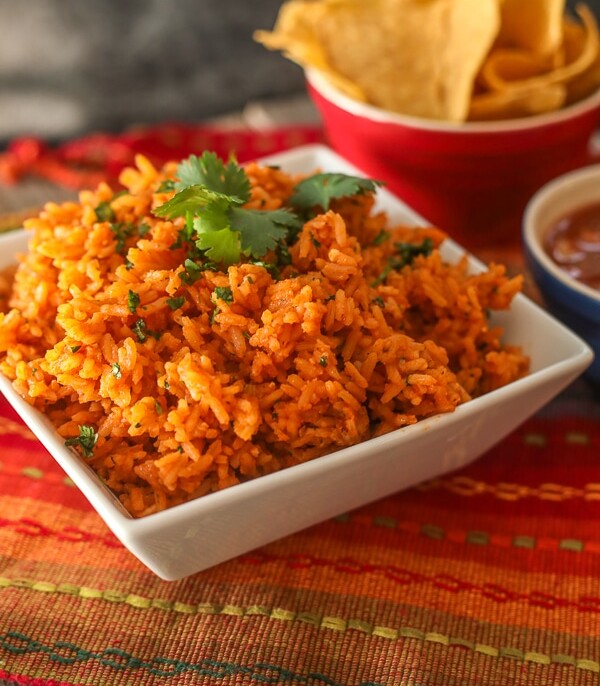Mexican Rice in a serving bowl with a side of chips and salsa.