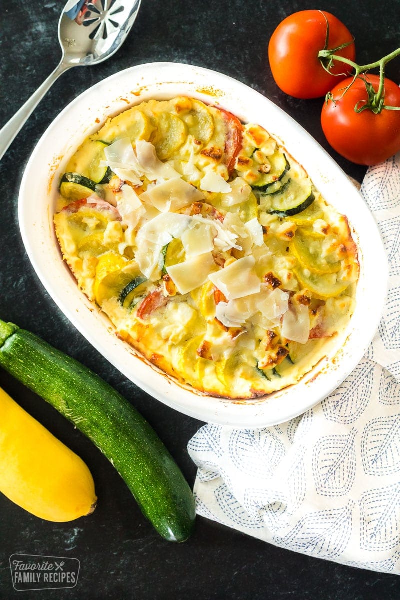 Yellow squash, zucchini, and tomatoes layered in a casserole dish