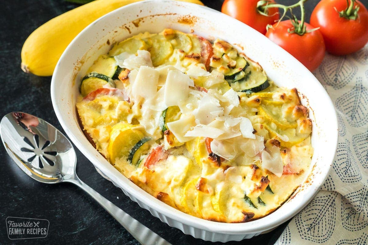 Zucchini and squash in a casserole dish with cheese melted on top. 