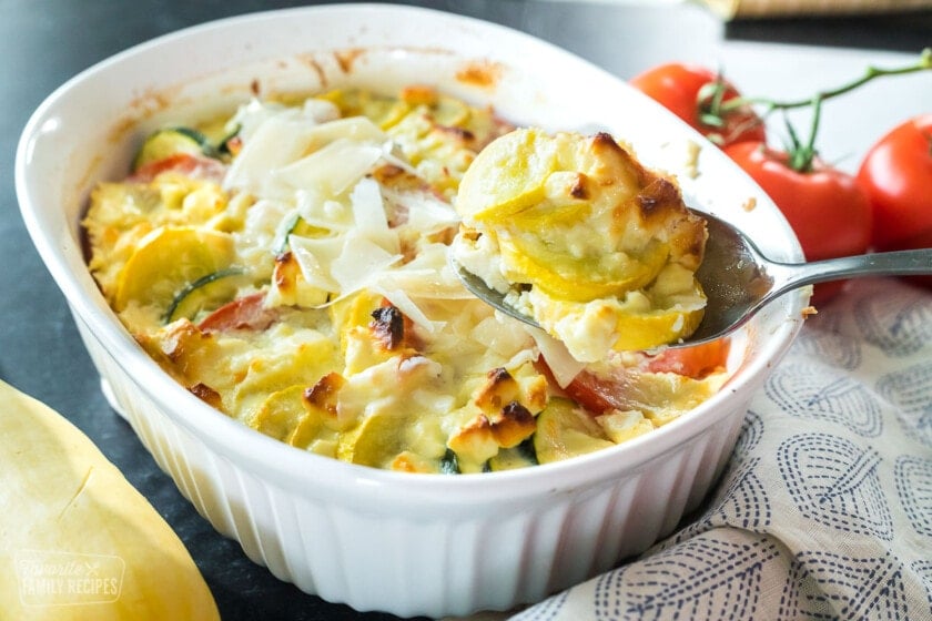 Parmesan squash casserole with a silver spoon.