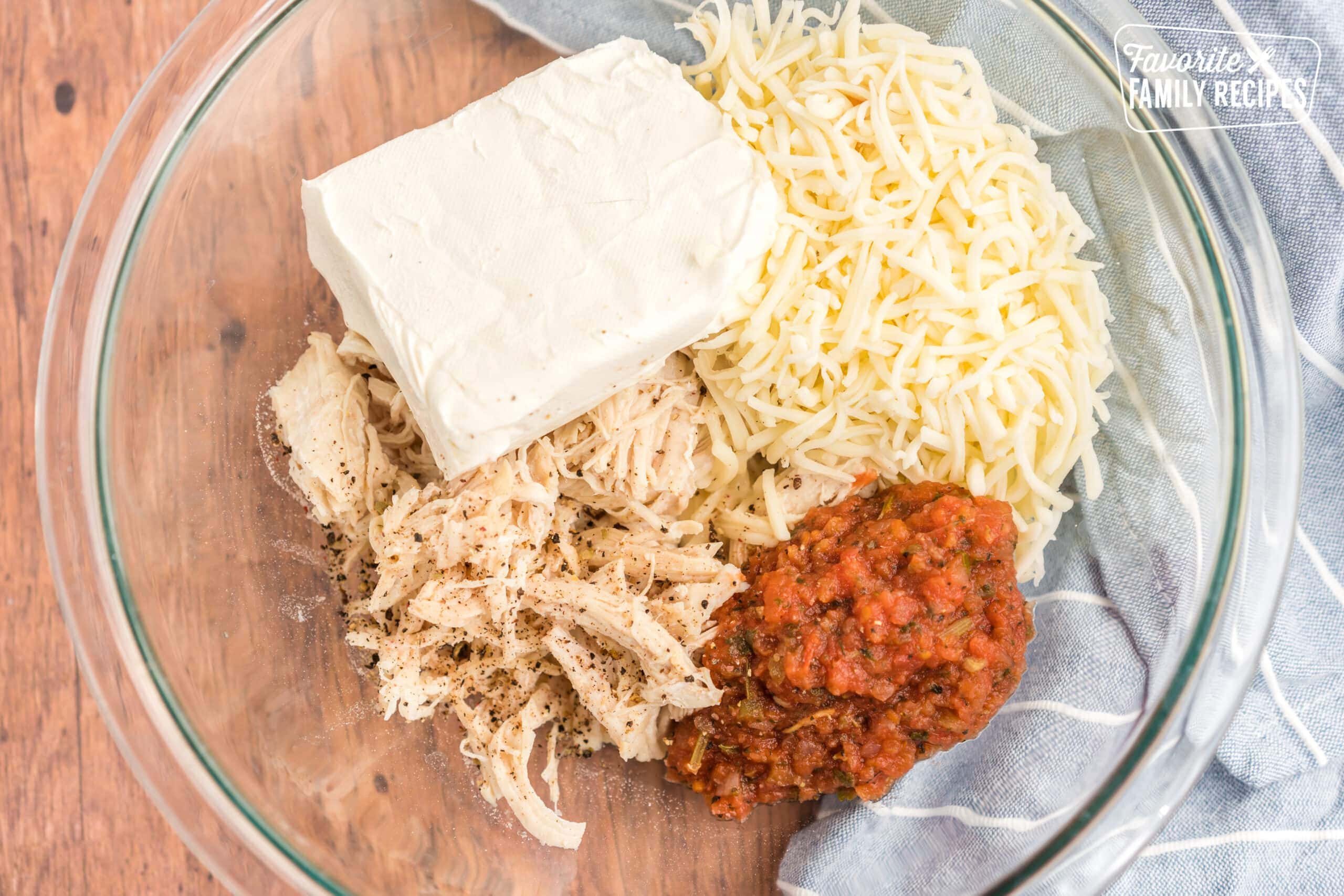 Chicken, cheese, salsa, and sour cream in a bowl