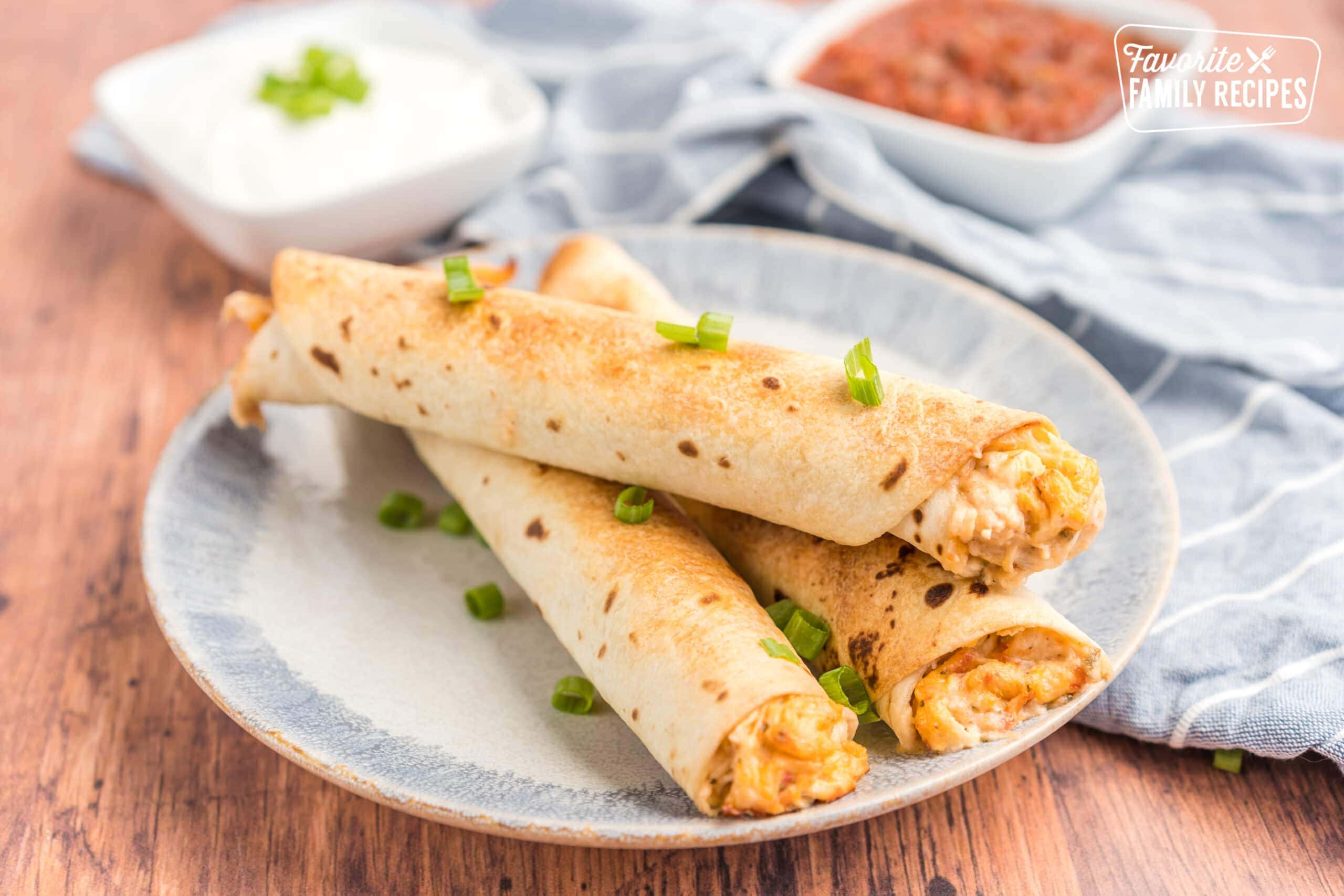 Three chicken flautas on a plate