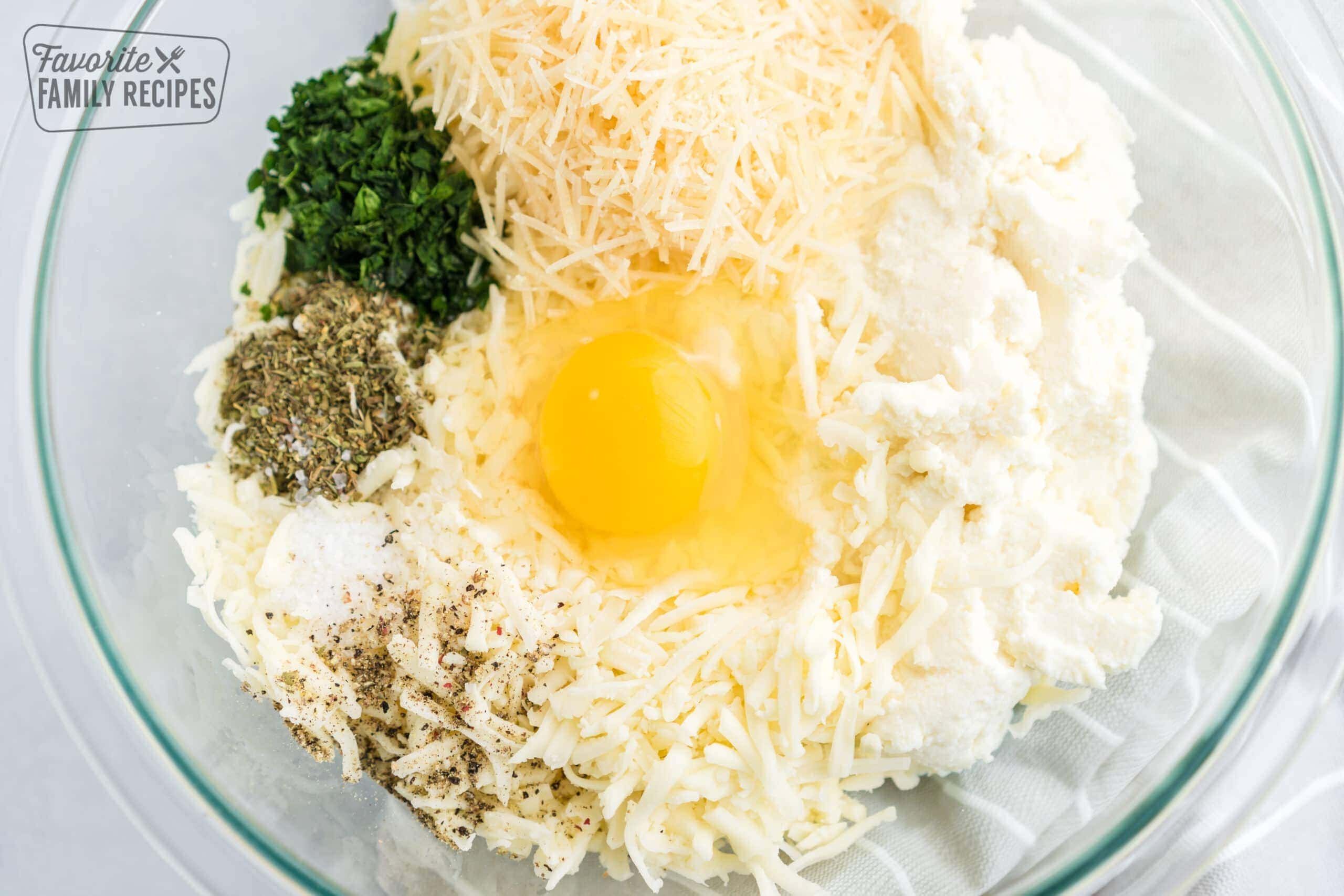 Cheese manicotti ingredients in a glass bowl ready to be combined.