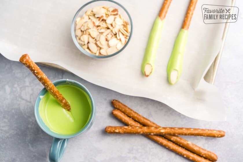 Long pretzel rods with green icing and a slice of almonds as fingernails.