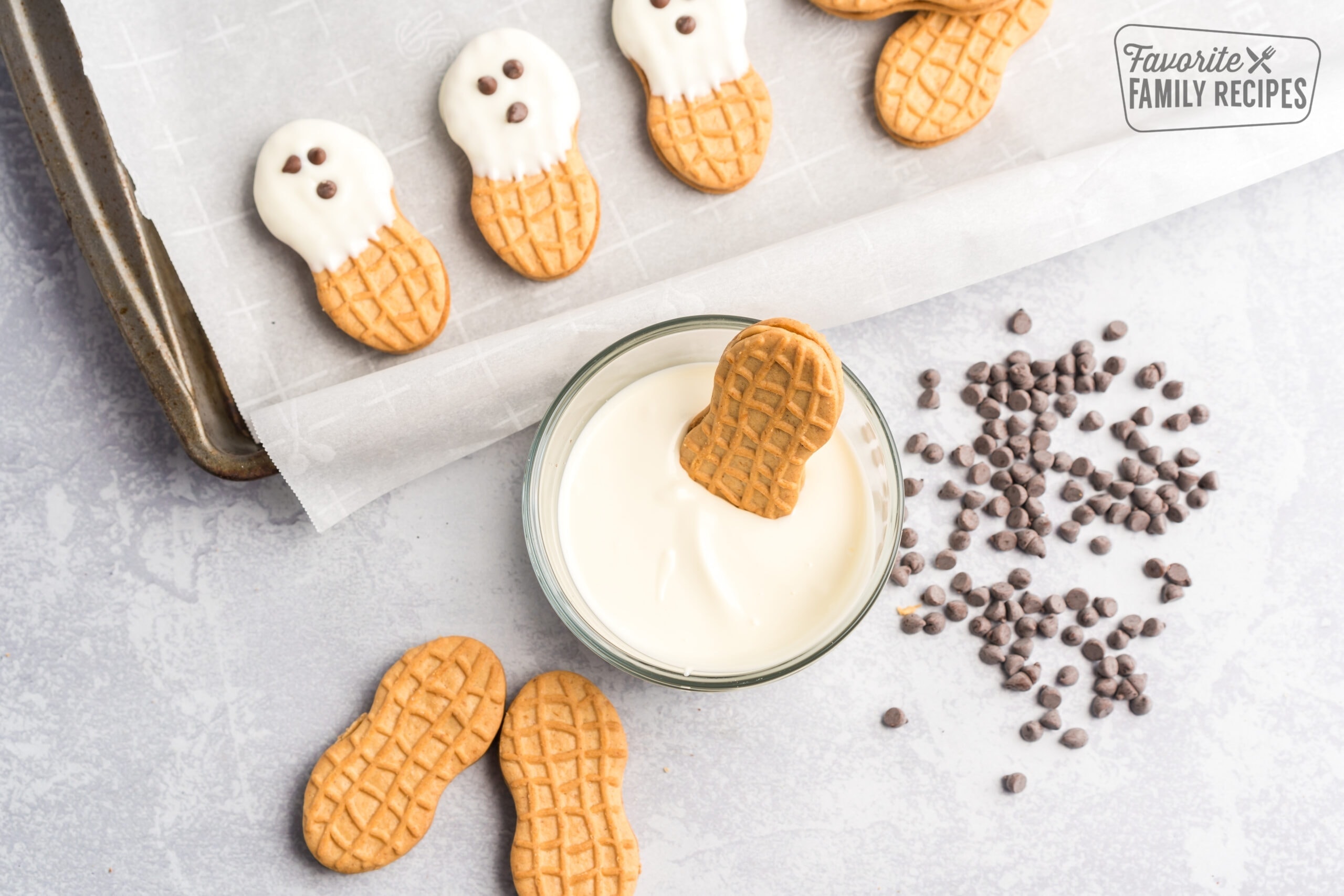 Nutter butters with white frosting and three chocolate chip eyes looking like ghosts.