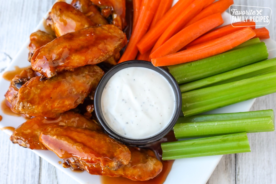 Overhead view of air fryer chicken wings on a plate with veggies and ranch dip