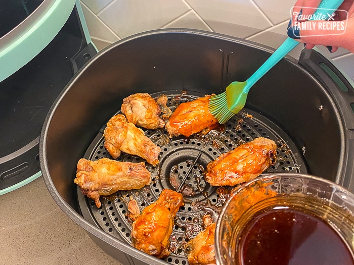 Brushing sauce on to wings in air fryer