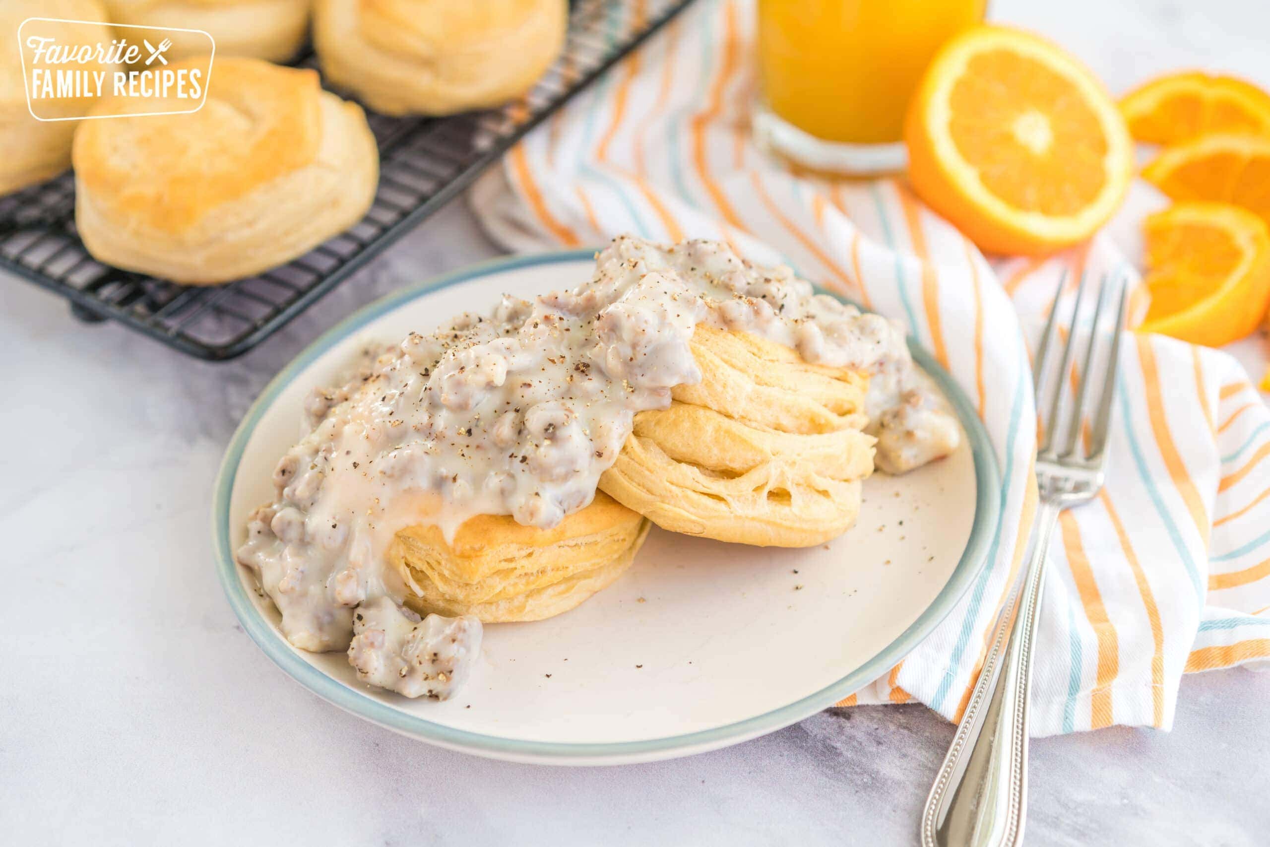 Two biscuits on a plate topped with sausage gravy