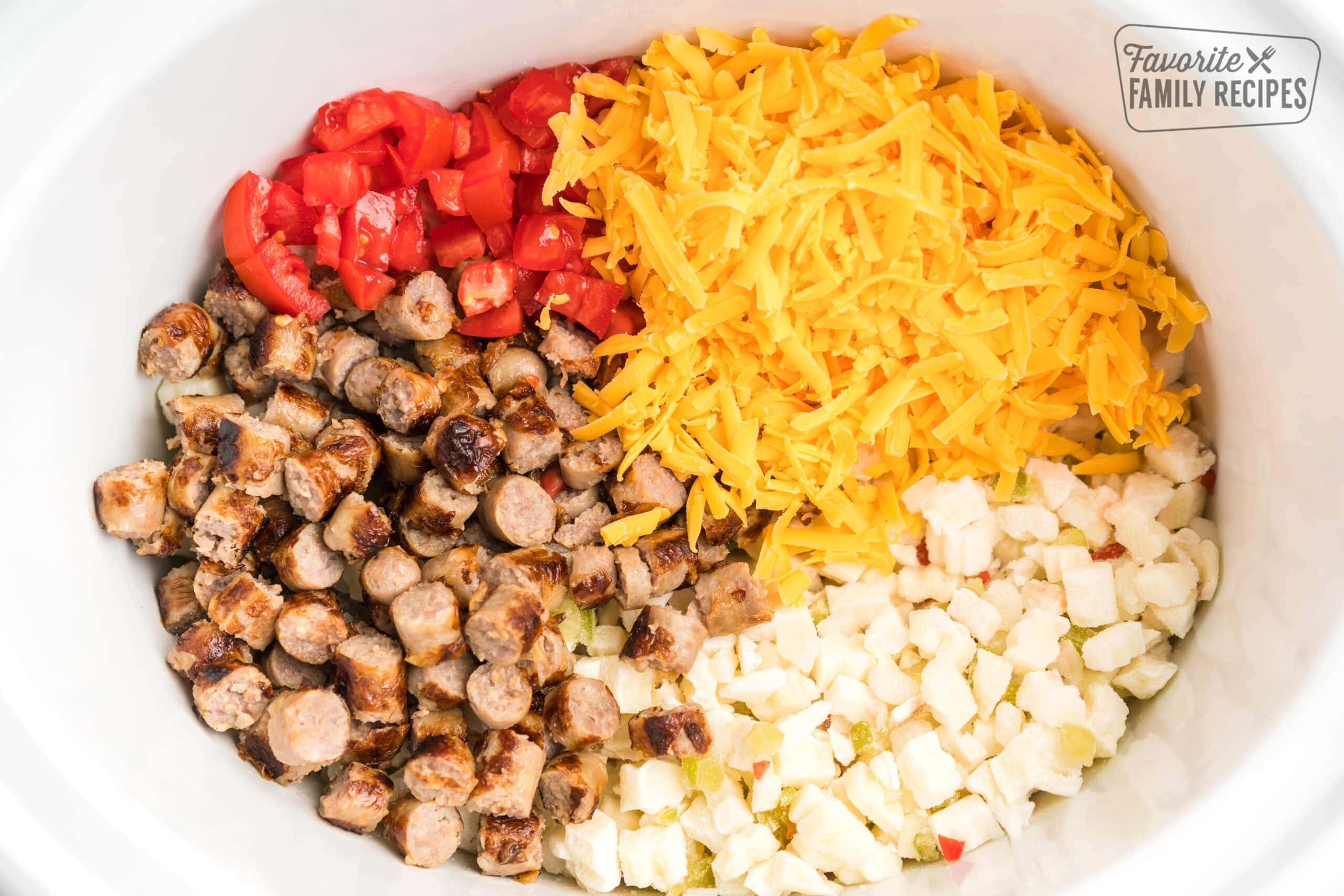 Potatoes, sausage, tomatoes, and cheese in a crock pot