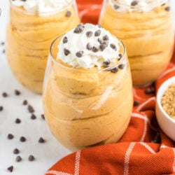 Pumpkin mousse cups topped with whipped cream and chocolate chips on top
