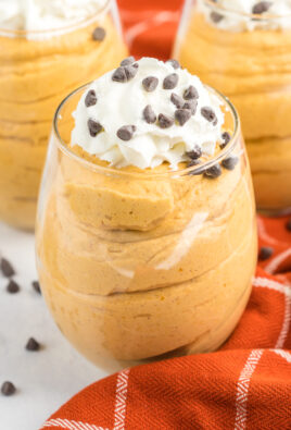 Pumpkin mousse cups topped with whipped cream and chocolate chips on top