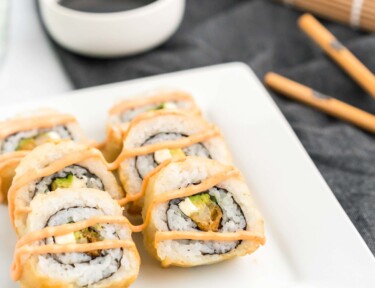 shrimp tempura rolls on a plate with soy sauce and chopsticks