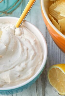 Dipping a chip into a bowl of clam dip