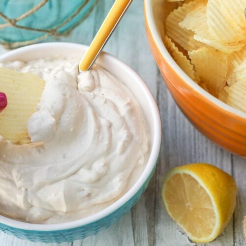 Dipping a chip into a bowl of clam dip
