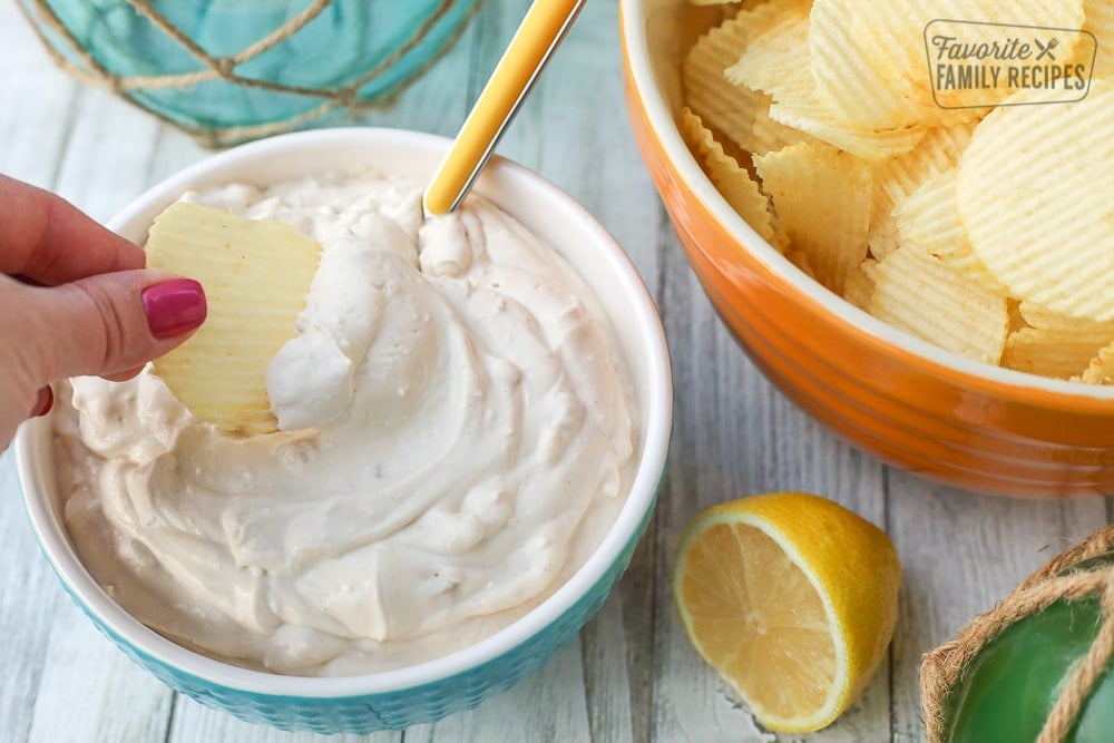 Dipping a chip into a bowl of clam dip.