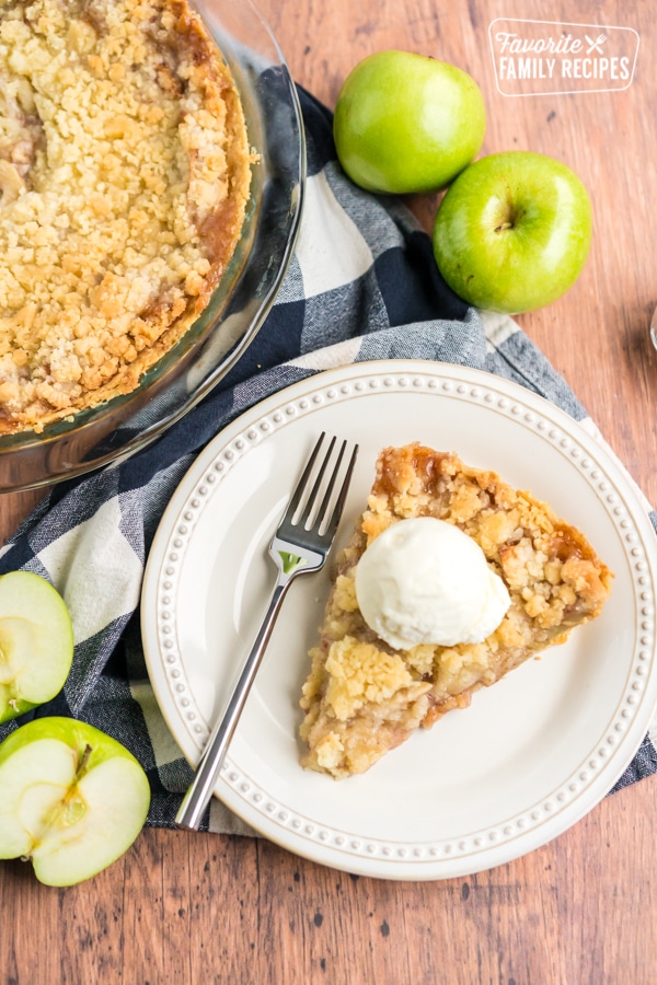 A whole Dutch apple pie with a slice of pie to the side.