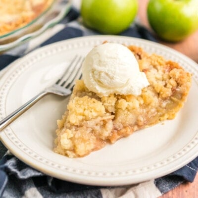 Slice of Dutch apple pie with a scoop of vanilla ice cream on top