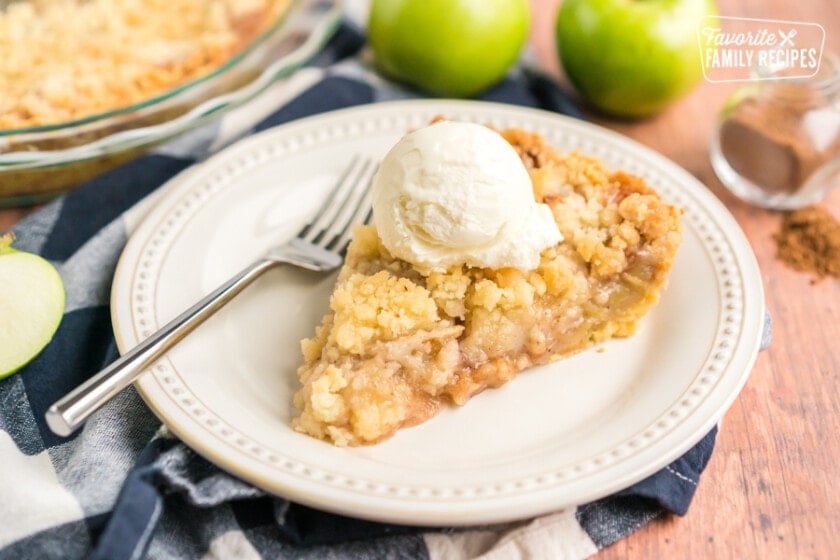 Slice of Dutch apple pie with a scoop of vanilla ice cream on top