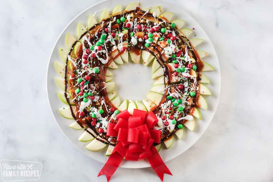 Edible wreath made from sliced apples, toppings, and candy