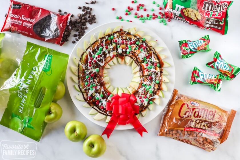 Apple wreath made from sliced apples, caramel, chocolate, and Christmas candies