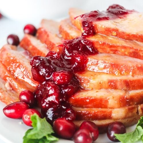 Close up of Christmas ham with cranberry sauce spooned over the top
