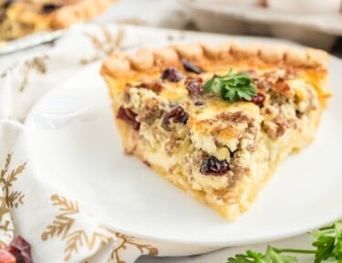 A slice of Christmas Breakfast Quiche on a white plate