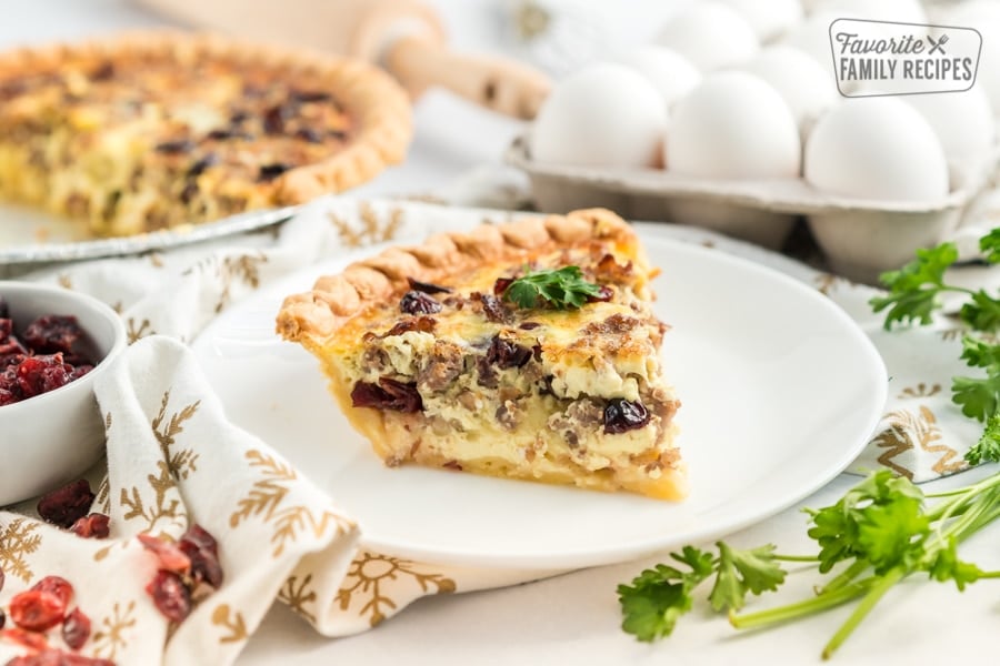 A slice of Christmas Breakfast Quiche on a white plate.