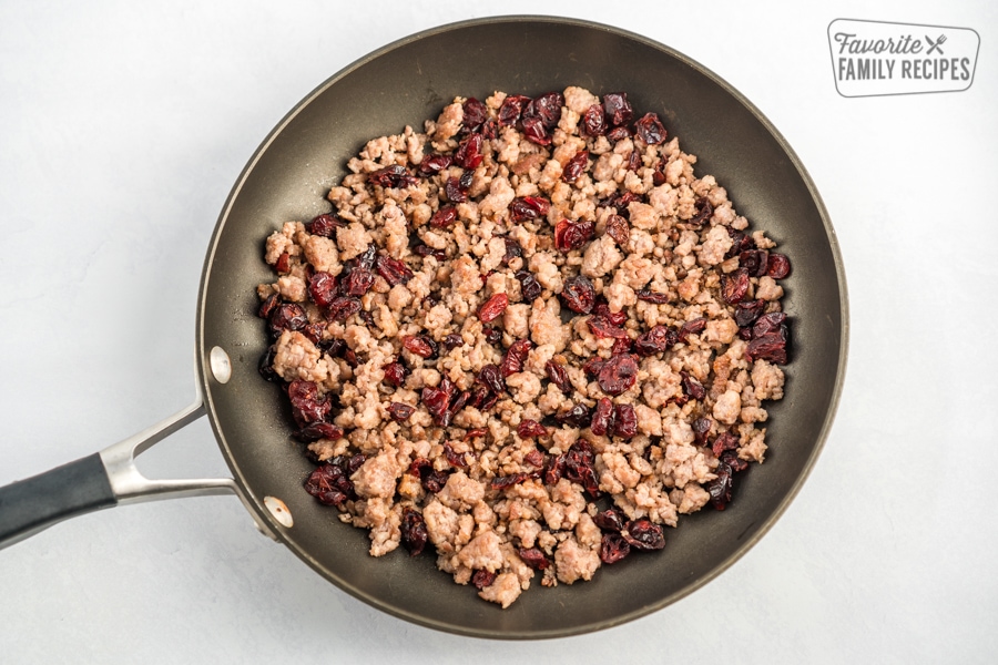 Browned sausage and dried cranberries in a skillet