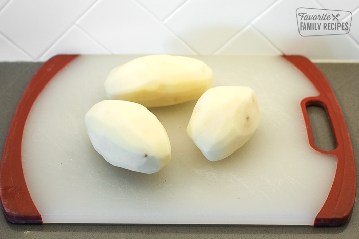3 potatoes on a cutting board