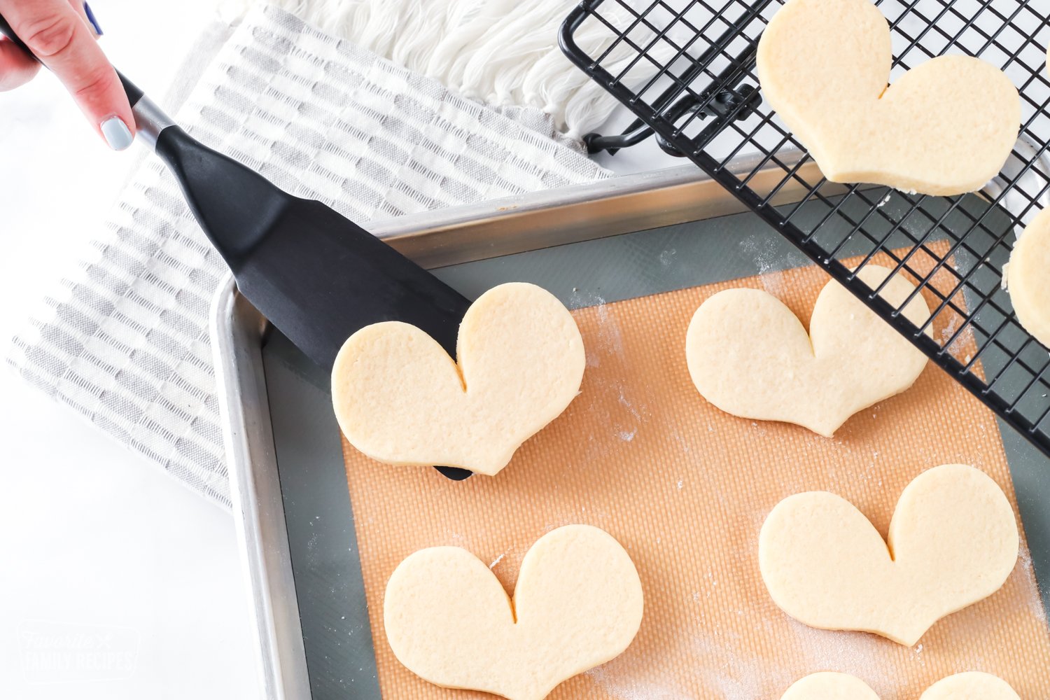 Sugar cookie being lifted from baking sheet with a spatula