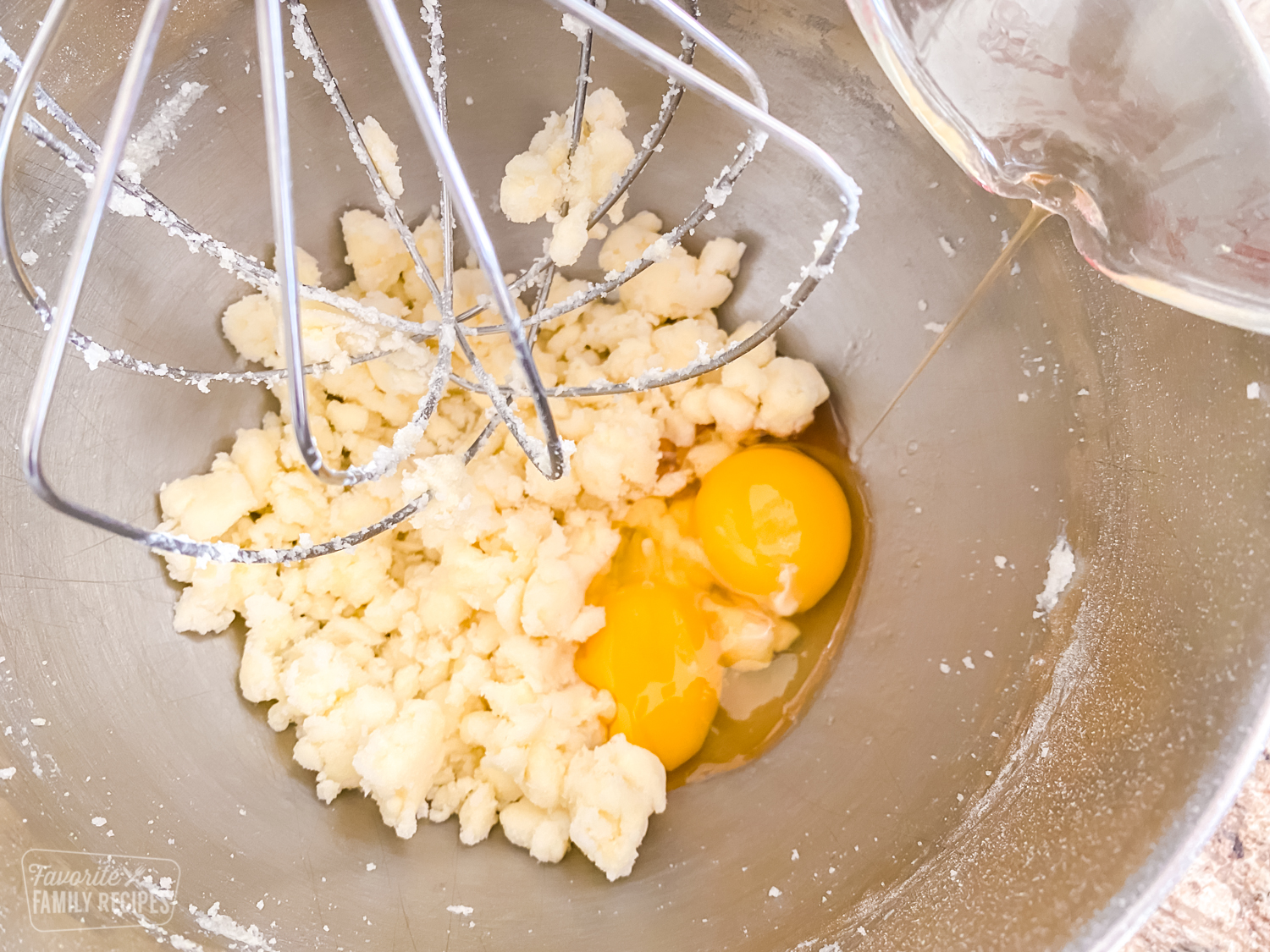 Eggs in a bowl being beaten with sugar and butter to make sugar cookies