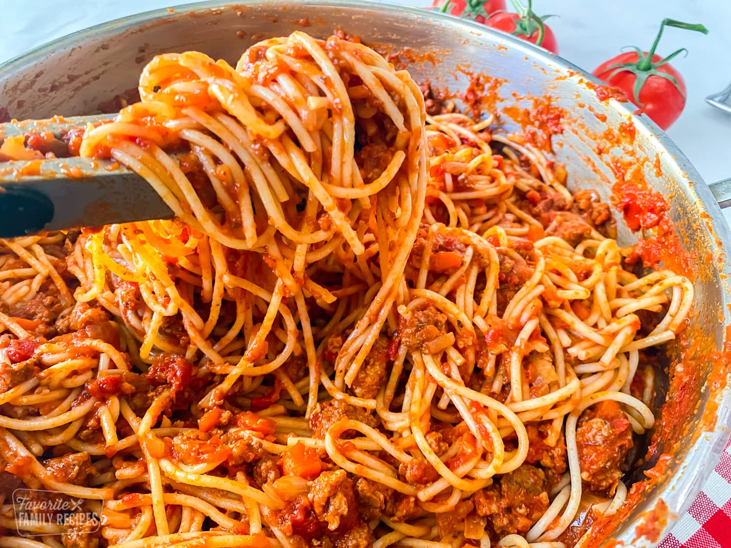 Spaghetti being served with tongs