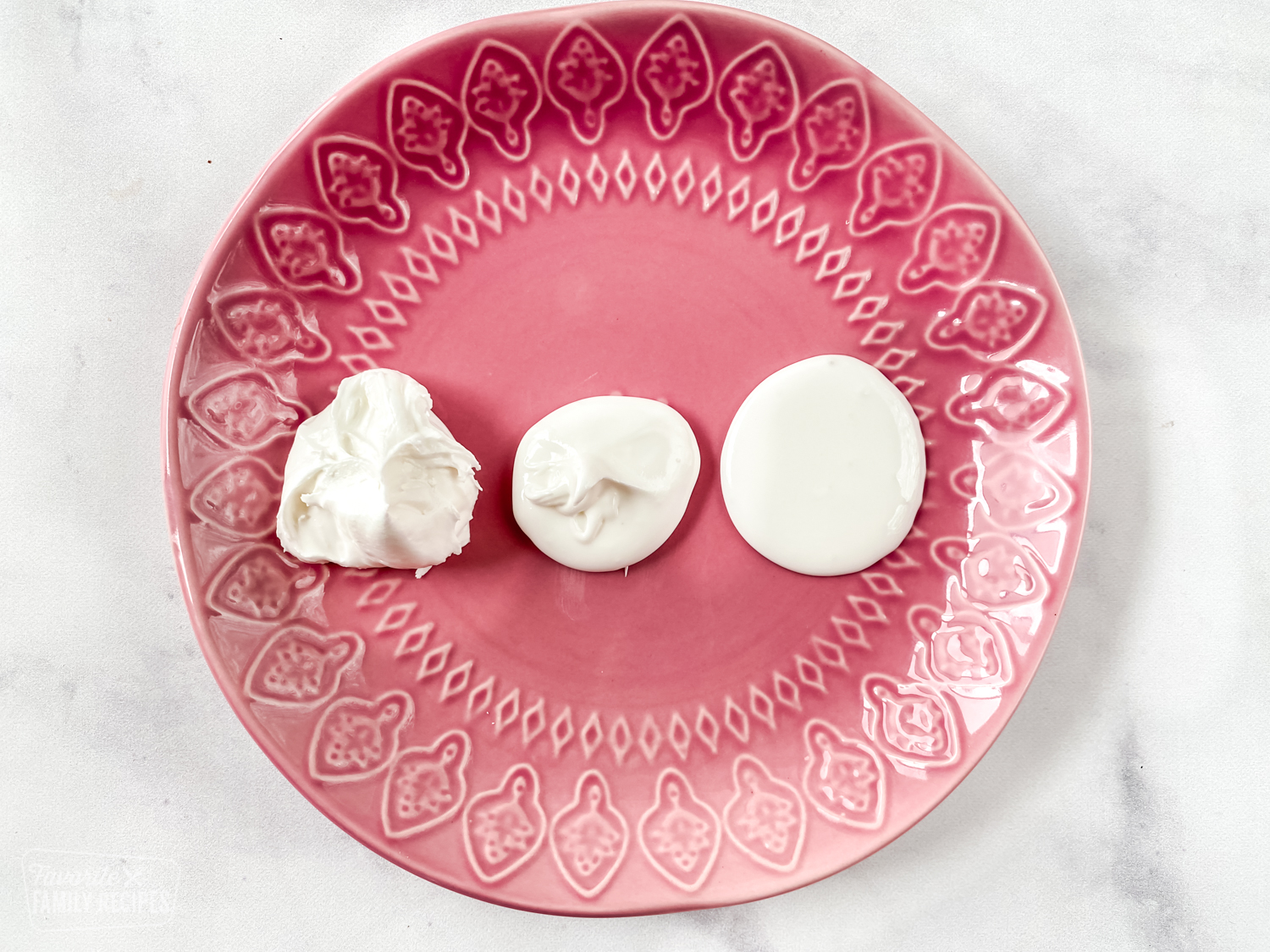 Three consistencies of royal icing on a plate