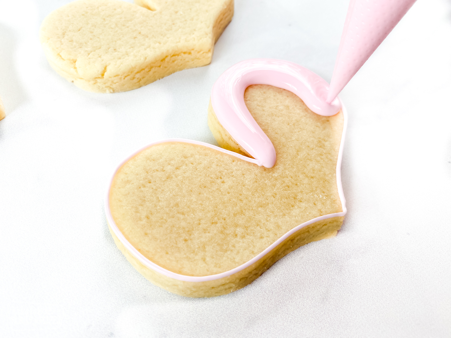 Sugar cookie with icing being piped on