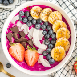 Acai bowl with bananas, coconut, blueberries, strawberries, and dark chocolate