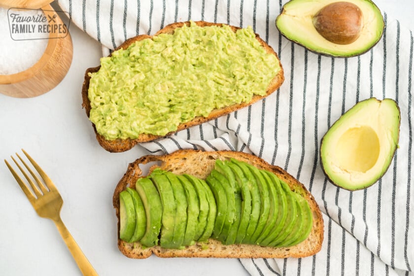 Two slices of toast, one with mashed avocado and one with sliced avocado