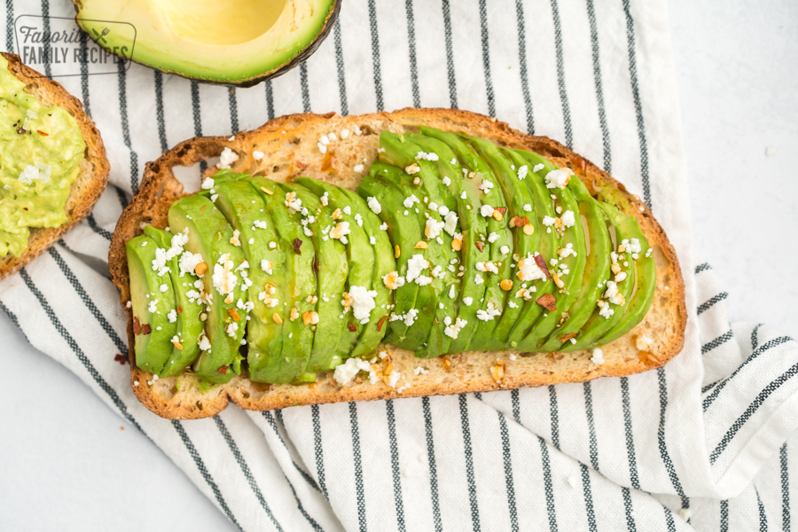 Toast with sliced avocado, feta, honey, and red pepper flakes