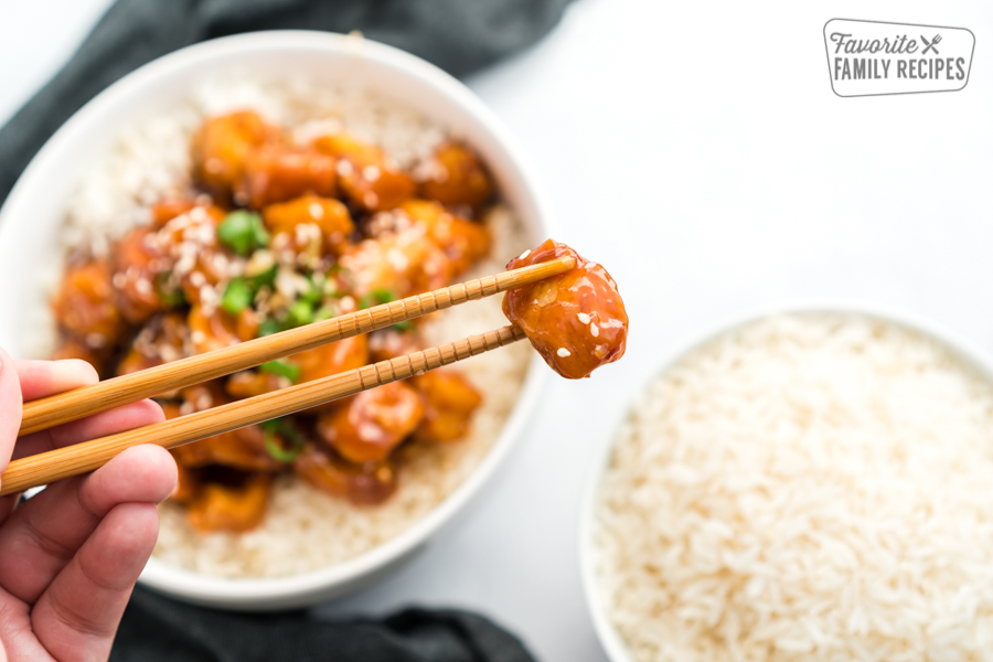 A piece of General Tso's Chicken held up with chopsticks.