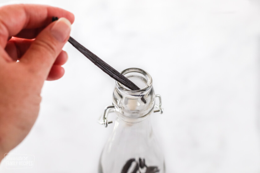 Placing a vanilla bean into a bottle to make vanilla extract