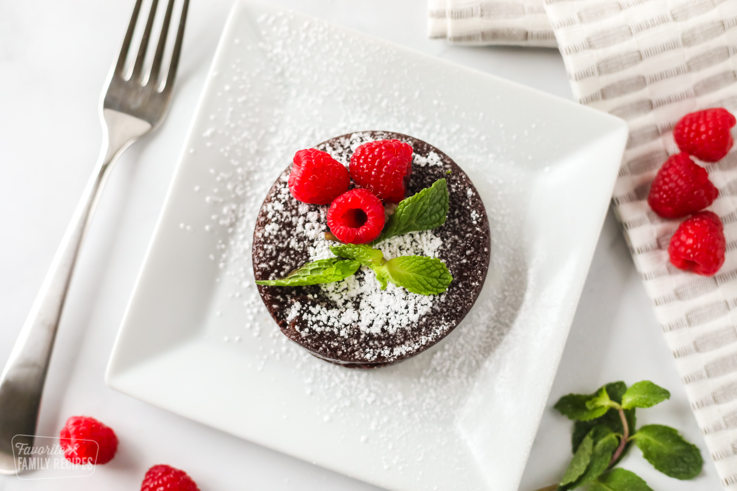 Small chocolate lava cake made in the instant pot on a plate with a fork.