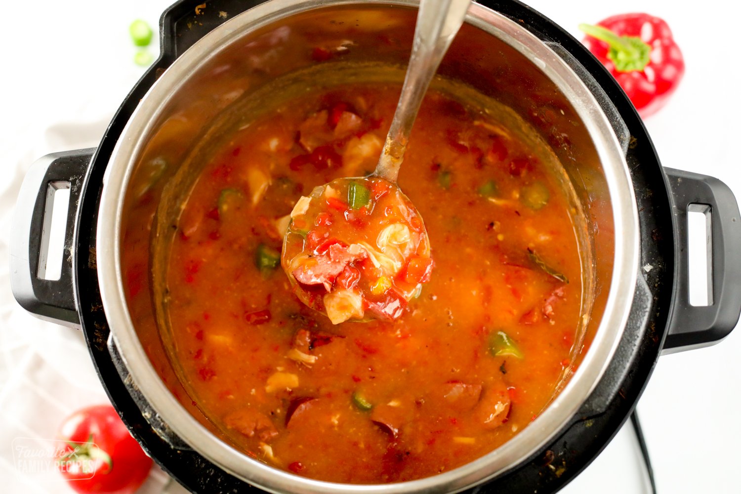 Gumbo in an Instant Pot being scooped with a ladle.