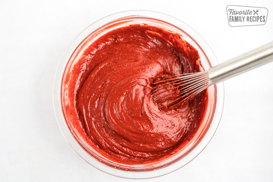 Red Velvet Cake Batter in a glass bowl with a whisk