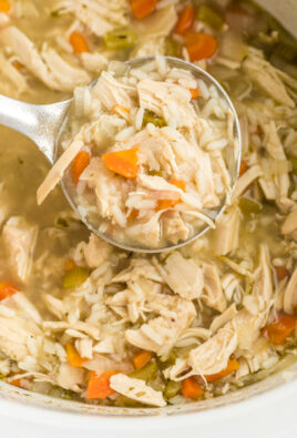 A ladle full of slow cooker chicken and rice soup