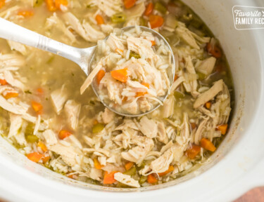 A ladle full of slow cooker chicken and rice soup