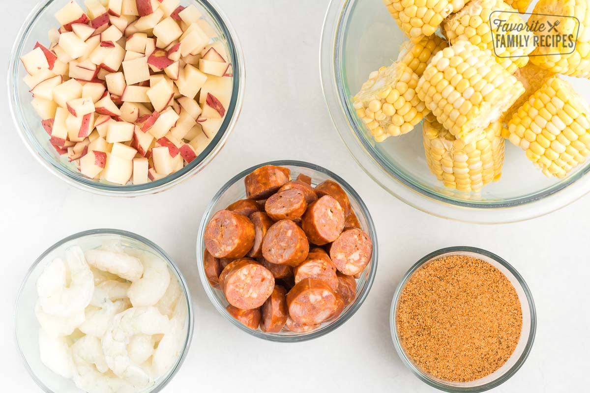 Little glass bowls, each one filled with a different ingredient: corn potatoes, sausage, shrimp, and Cajun Seasoning