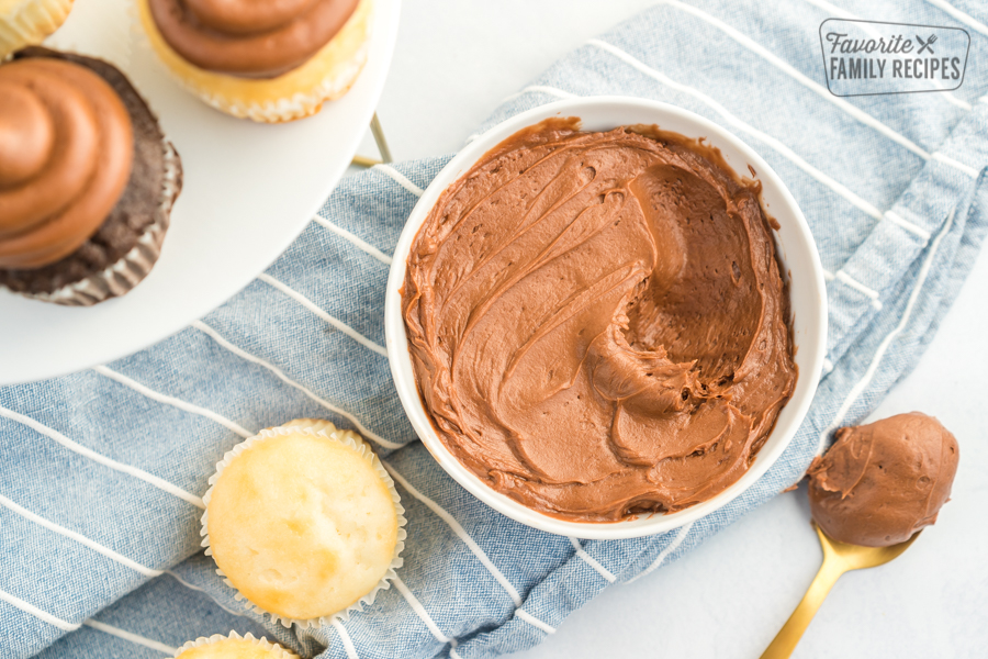 A bowl of Chocolate Buttercream Frosting with a spoonful scooped out