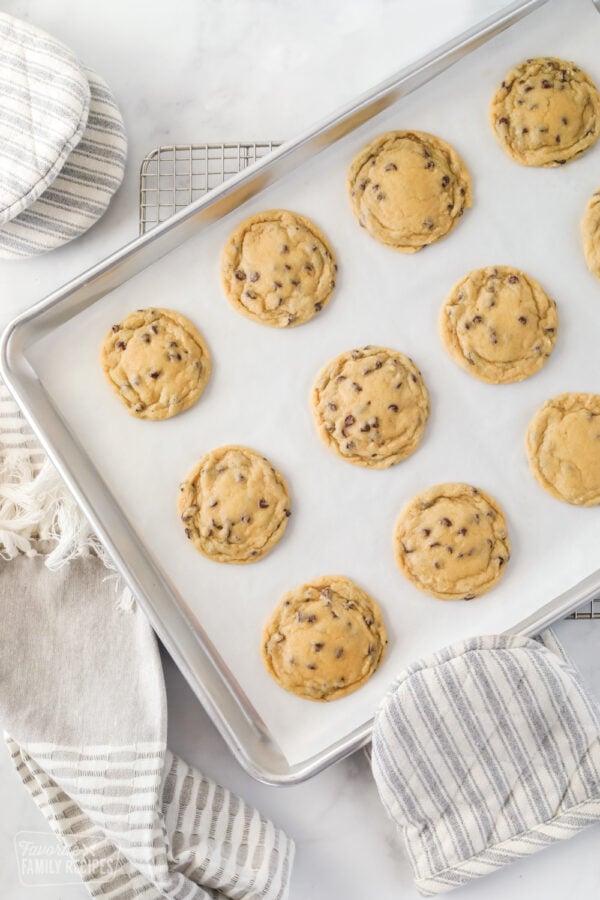 Chocolate chip cookies made with sugar, butter flour, eggs, and chocolate chips on a baking sheet